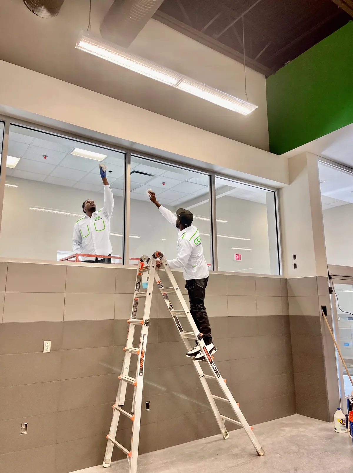 Cleaning Concepts Plus technicians in white CCP-logo uniforms cleaning commercial interior glass in Birmingham, AL
