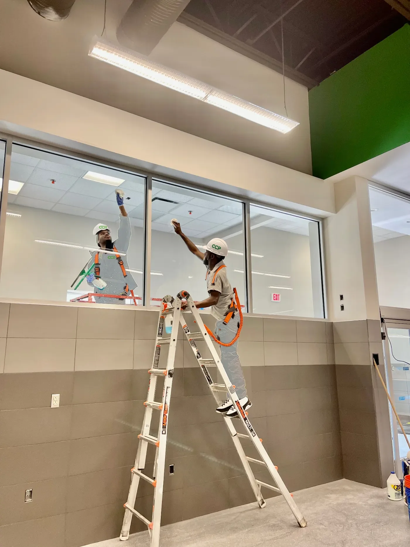 Interior window cleaning by a uniformed Cleaning Concepts Plus team member